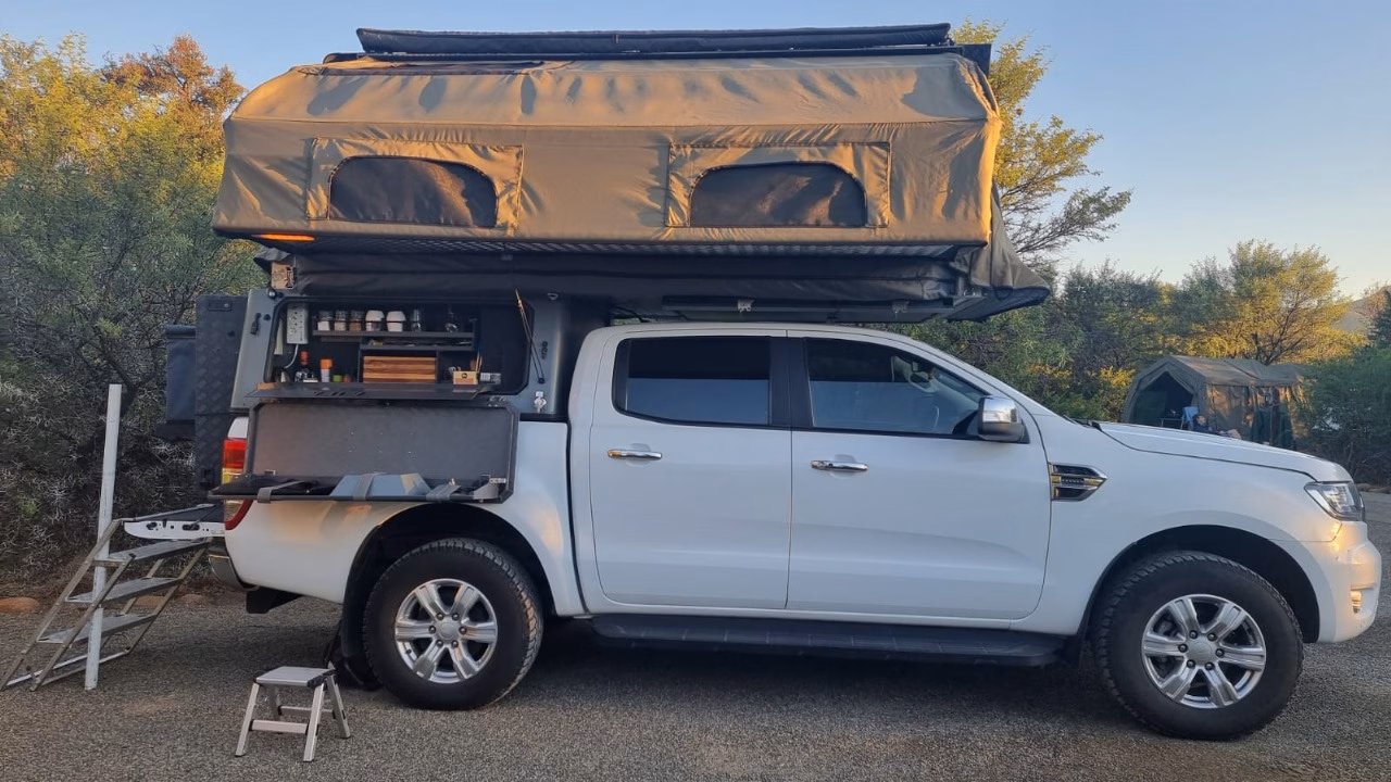 An AHA Transformer open on a white Ford Ranger double cab, kitchen out and ladder down.