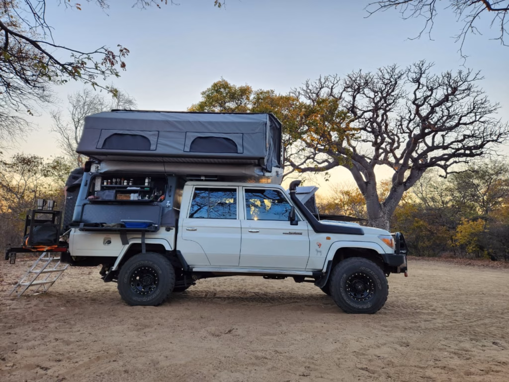 AHA Transformer mounted on a Land Cruiser double cab AHA Transformer mounted on a Toyota Land Cruiser double cab, with the kitchen open and the roof lifted. A calm bushveld setting in the background with trees glimmering at dusk.