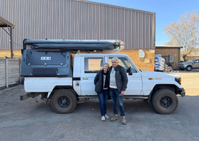 Andy and Margie Carr with their AHA Transformer on a Toyota Land Cruiser Double Cab, collected at the AHA Outdoor Systems factory, 2025.
