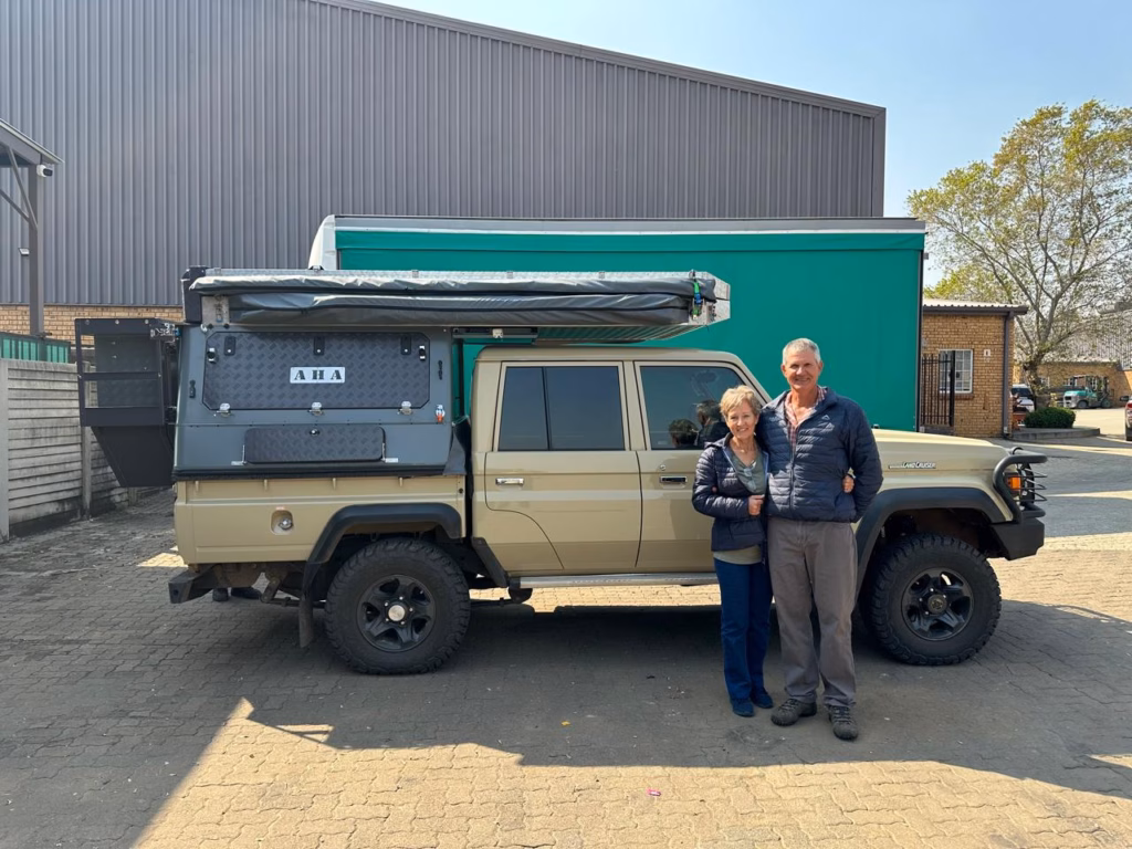 Henk & Gerda Van Rensburg | Toyota Land Cruiser Double Cab | Dendron, Limpopo Henk and Gerda Van Rensburg with their AHA Transformer on a Toyota Land Cruiser Double Cab, collected at the AHA Outdoor Systems factory, 2025.