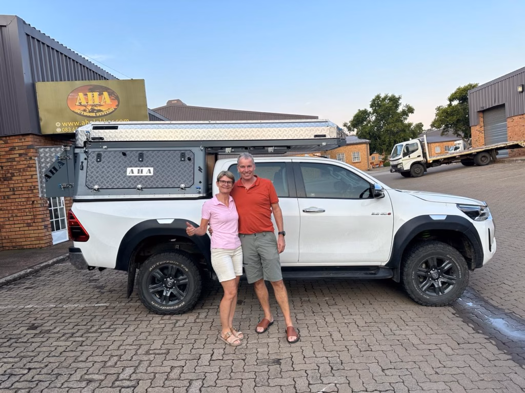 Marcel & Georgia Staudt | Toyota Hilux Double Cab | Switzerland Marcel and Georgia Staudt with their AHA Transformer on a Toyota Hilux Double Cab, collected at the AHA Outdoor Systems factory, January 2024.