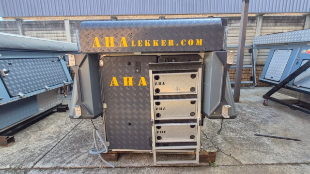 Pre-owned 2024 model AHA Transformer seen from behind, fully closed, with the 3-step ladder mounted to the back.