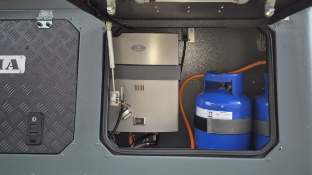 Gas geyser and gas bottle storage area of a pre-owned 2023 AHA Transformer.
