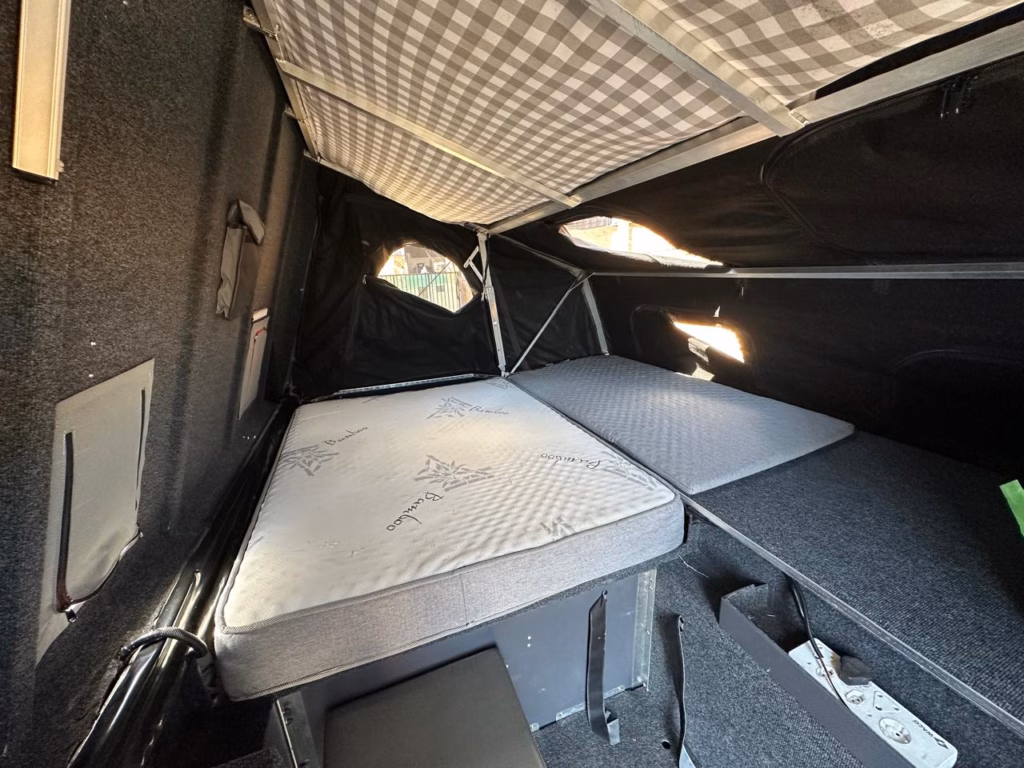 Double bed with its mattress and the additional small mattress alongside.