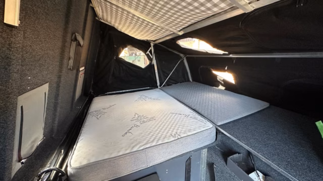 Double bed with its mattress and the additional small mattress alongside.